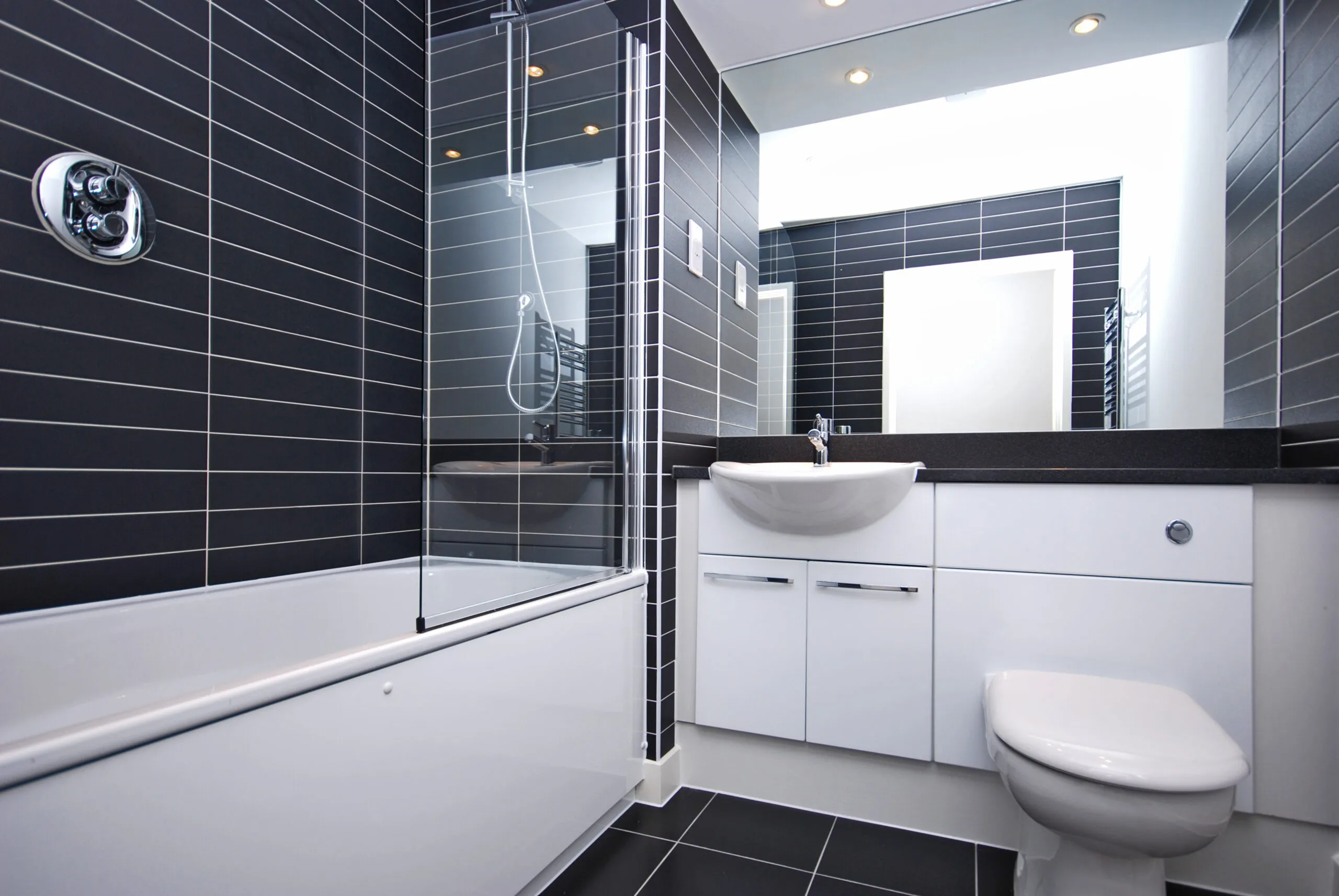 a white toilet sitting next to a white bath tub