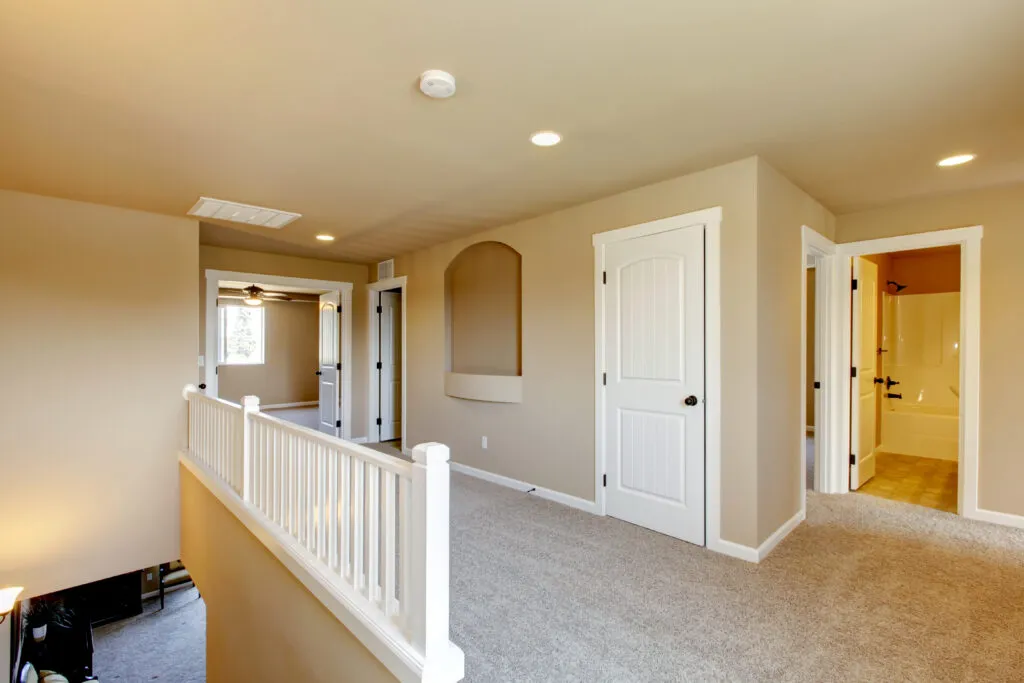 a large empty room with a staircase leading to a second floor