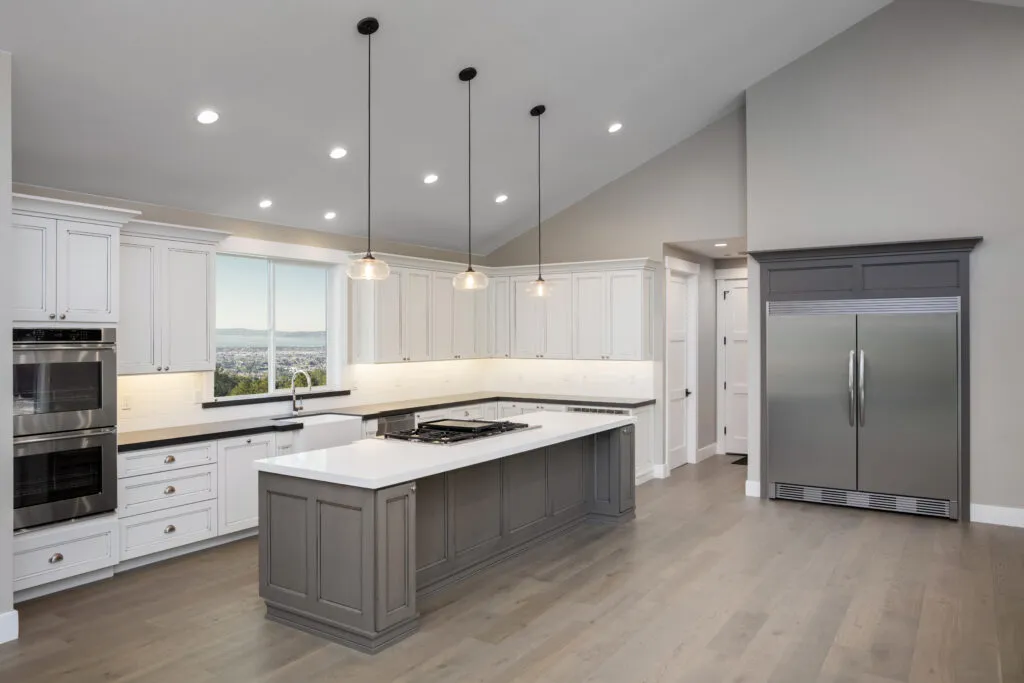 a large kitchen with a center island and a refrigerator